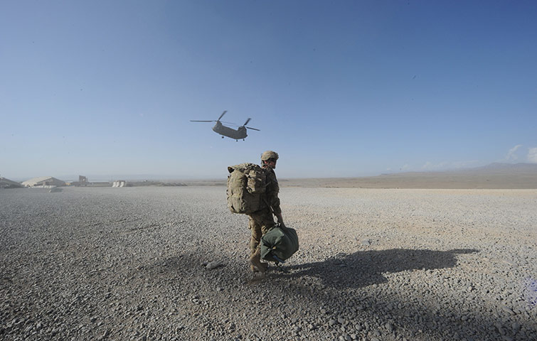 A US soldier walks as a Chinook helicopter prepares to land at Forward Operating Base Sharano.