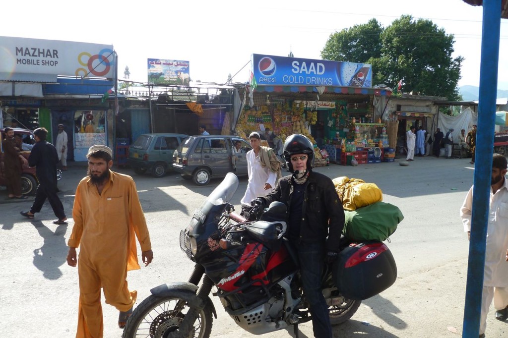 A foreign tourist on his motorbike on the Karakoram Highway, Besham bazaar.